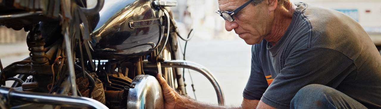 Man sleutelt aan motorfiets